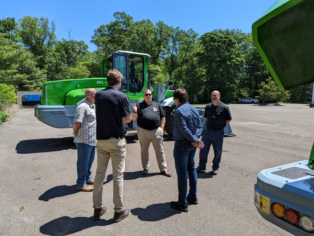 About Us HEVI employees answering questions about electric heavy equipment